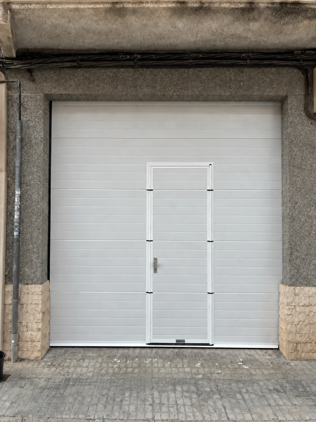 Puerta seccional con peatonal integrada en Beniparrell