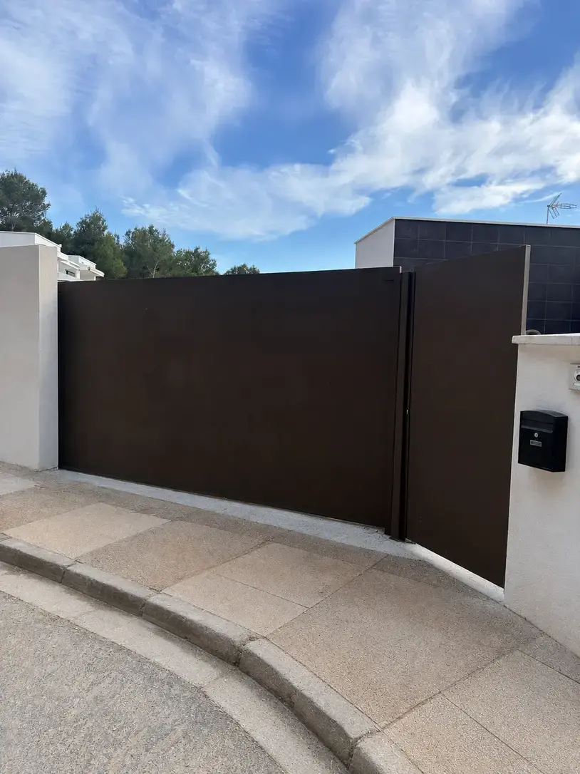 Puerta corredera fabricada a medida con peatonal integrada en El Bosque, Chiva.