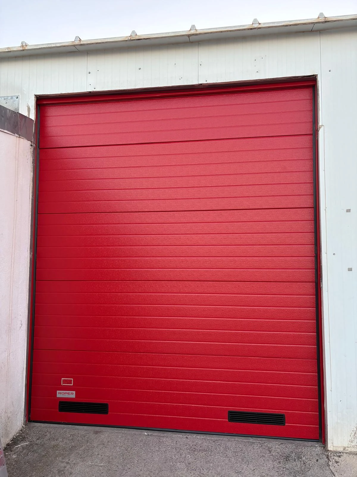 Resultado exterior: nueva puerta seccional roja instalada en Chiva.