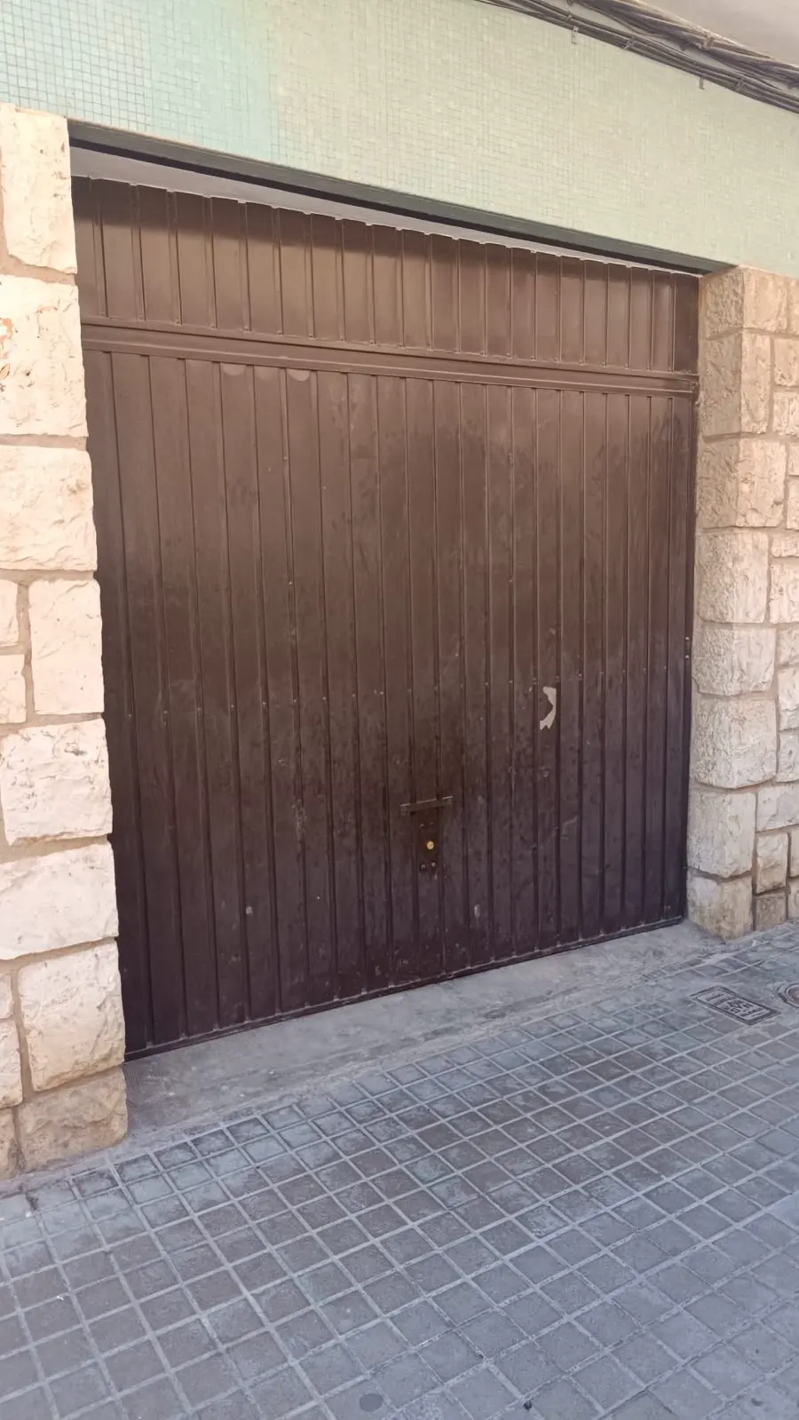 Antes: antigua puerta basculante vista desde la calle. Manises