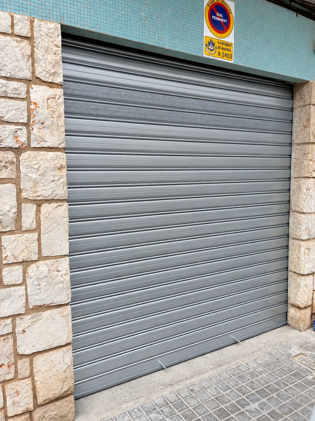 Resultado: puerta enrollable galvanizada motorizada con dos lamas microperforadas.