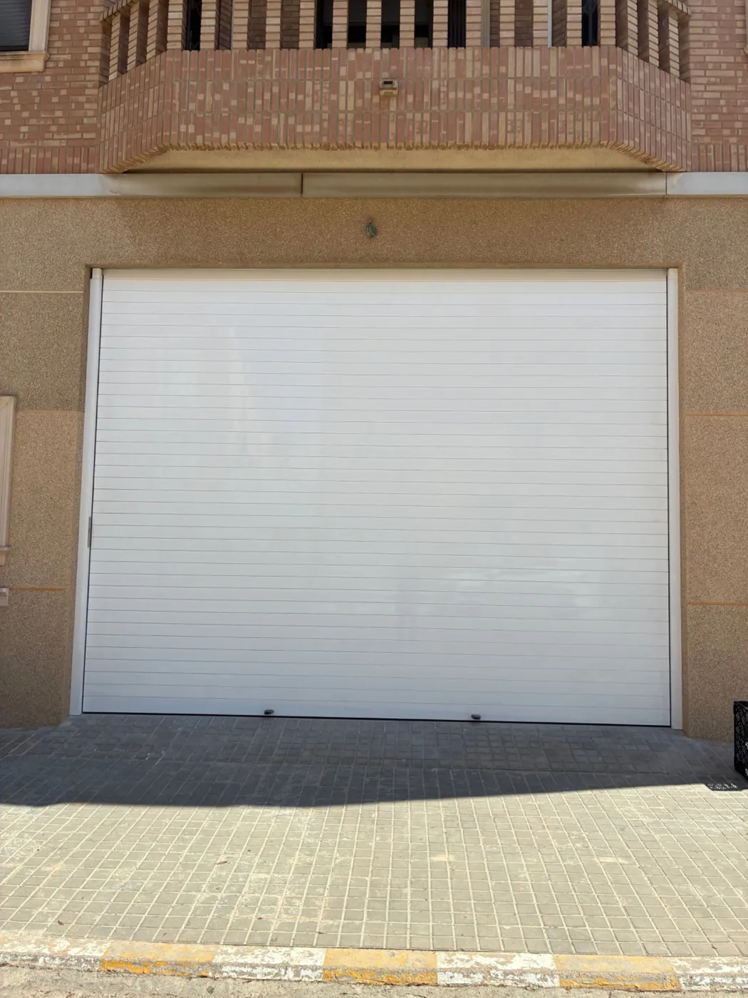 Después: puerta enrollable de aluminio blanca.